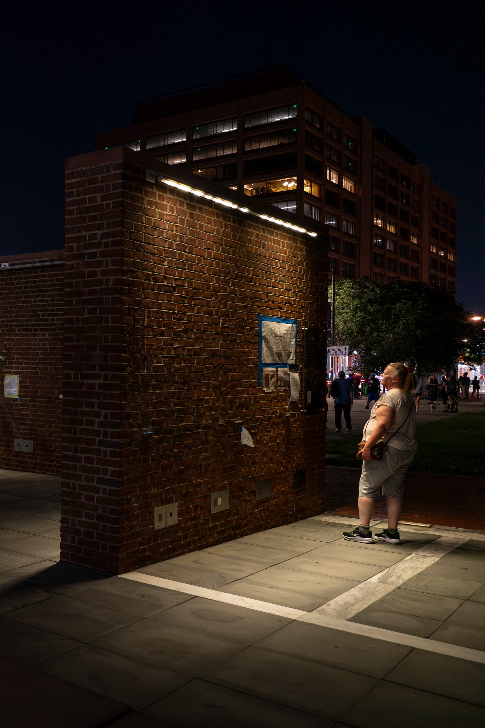 A visitor to The President's House looks on a information added to a wall that once included information about the enslaved at the site. Photo: M. Edlow